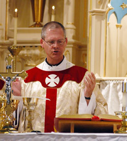 Then-Father Paul Etienne prays part of the eucharistic prayer during a March 19 Mass at St. Joseph Church in Jennings County. The Mass celebrated the completion of the restoration of the church, where Father Etienne once served as a sacramental minister. (File photo by Mary Ann Wyand) 