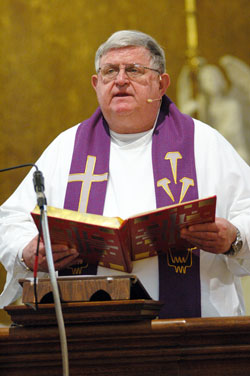 Conventual Franciscan Father Joel Burget proclaims the Gospel during Mass on March 22 at St. Benedict Church in Terre Haute. He served as a missionary priest in Zambia for 23 years. (File photo by Mary Ann Wyand)
