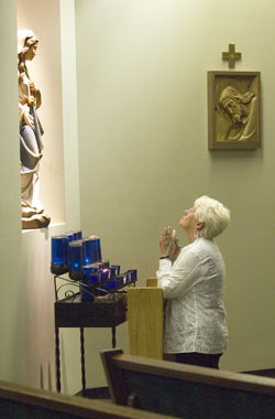 Mary Winnecke takes time after Mass to pray at Holy Redeemer Church in Evansville, Ind., in the Evansville Diocese, on Aug. 19. Winnecke’s daughter, Natalie Fulkerson, was killed by Matthew Eric Wrinkles in 1994. Wrinkles is on death row, but Winnecke opposes the death penalty. Winnecke says that her faith has allowed her to forgive Wrinkles. Read her story of faith and forgiveness on page 9. (Photo courtesy Molly Bartels/ Evansville Courier & Press)