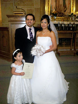Idelfonso Orlando Mondragon Garfias and Leticia Calderon Anzures pose for a wedding photograph with their 3-year-old daughter, Michelle, after their 2005 civil marriage in Mexico was convalidated in the Church during an Oct. 31 nuptial Mass at St. Philip Neri Church in Indianapolis. They were among seven Hispanic couples who were married during the same liturgy. (Submitted photo)