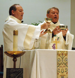 Deacon David Henn and Msgr. Mark Svarczkopf, pastor of Our Lady of the Greenwood Parish in Greenwood, elevate the chalice and paten at the end of the eucharistic prayer during a Nov. 11 Mass at the parish’s church. (Photo by Sean Gallagher)