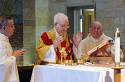 Msgr. Richard Kavanagh, center, prays a eucharistic prayer during a June 2, 2006, Mass at St. Paul Hermitage in Beech Grove on the occasion of the 70th anniversary of his priestly ordination. Concelebrating with him were, from left, Father Henry Brown and Father John Sciarra, both retired priests in residence at the Hermitage. Msgr. Kavanagh died on Jan. 20. Father Brown died in 2009, and Father Sciarra died in 2007. (File photo by Sean Gallagher)
