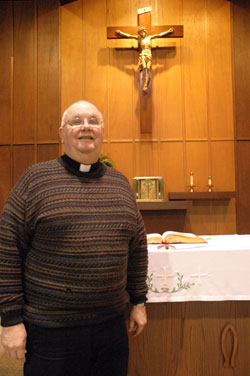Father John Hall stands by the altar on Jan. 21 at St. Martin of Tours Church in Martinsville, where he has served as pastor since 2005. He is also the administrator of Our Lady of the Springs Parish in French Lick and Our Lord Jesus Christ the King Parish in Paoli. (Photo by Sean Gallagher)