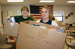 Catherine Aubrey, left, and Hadley Anderson, juniors at Our Lady of Providence Jr./Sr. High School in Clarksville, carry boxes of toys on Dec. 11, 2009, that were donated to the Marine Foundation Toys for Tots to the school’s lobby. The toy drive at Providence was organized by the school’s House of Justice and House of Faith. Students from all four grade levels in the senior high school are arranged in eight houses in a new student leadership model launched last fall at Providence. (Submitted photo)