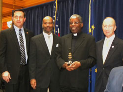 Indiana Gov. Mitch Daniels, right, presented a 2010 Freedom Award to Father Kenneth Taylor, third from right, during a Jan. 14 ceremony at the Indiana Statehouse. State Rep. Matthew Bell, R-Avilla, left, and Clayton Graham, second from left, also participated in the award presentation. Father Taylor is the pastor of Holy Angels Parish in Indianapolis and director of the archdiocesan Office of Multicultural Ministry. (Submitted photo/courtesy Governor’s Office)