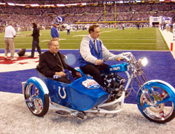 Archbishop Daniel M. Buechlein rides in the sidecar of the motorcycle that led the Indianapolis Colts into Lucas Oil Stadium for their AFC Championship victory over the New York Jets on Jan. 24. Driving the archbishop is Forrest Lucas. The stadium is named after Lucas’ oil products company, which bought the naming rights to the stadium. Archbishop Buechlein rode with Lucas to show his support for the Indianapolis Colts “as strong examples of positive role models and community involvement.” (Submitted photo)