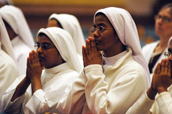 Sister Saima Mary, left, and Sister Rosalind Mary, both members of the Franciscan Sisters of the Immaculate Heart of Mary, kneel in prayer during the Jan. 31 World Day for Consecrated Life Mass at SS. Peter and Paul Cathedral in Indianapolis. Both sisters minister at St. Francis Hospital in Beech Grove. (Photo by Sean Gallagher)