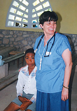 Registered nurse Sue Alexander prepares to help a Haitian boy during one of her medical mission trips to St. Jean Marie Parish in Belle Riviere with St. Thomas Aquinas Parish Haiti Committee volunteers. Alexander miraculously survived the Jan. 12 earthquake in Port-au-Prince. (Submitted photo)