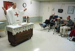 Residents of the Beech Grove Meadows Nursing Home in Beech Grove pray while Father Stanley Pondo celebrates Mass on Feb. 10. Father Pondo is the pastor of Most Holy Name of Jesus Parish in Beech Grove. (Photo by Sean Gallagher)