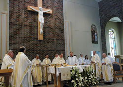 Nine priests assisted Archbishop Daniel M. Buechlein with the Mass of Dedication and Consecration of the New Altar on Feb. 28 at the new St. Anne Church in New Castle. The parish children raised the money to pay for the oak cross which holds the large corpus and hangs above the altar. (Photo by Mary Ann Wyand)