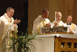 Archbishop Daniel M. Buechlein, left, Bishop Paul D. Etienne of Cheyenne, Wyo., and Benedictine Archabbot Justin DuVall of Saint Meinrad Archabbey in St. Meinrad pray during the eucharistic prayer of the chrism Mass on March 30 at SS. Peter and Paul Cathedral in Indianapolis. Father Patrick Beidelman, right, archdiocesan director of worship and a master of ceremonies at the Mass, concelebrates the eucharistic prayer. (Photo by Sean Gallagher)
