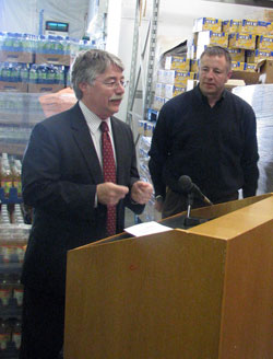 Indiana Attorney General Greg Zoeller, left, speaks at a March 16 news conference at the Terre Haute Catholic Charities Food Bank. John Etling, right, executive director of Catholic Charities Terre Haute, also participated at the gathering during which Zoeller announced the second annual “March Against Hunger” food drive. The initiative is a friendly competition among lawyers and law offices to raise the most donations for regional food banks that serve the hungry. (Photo courtesy of Indiana Attorney General’s Office)
