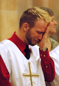 Catechumen Eugene Earls of Indianapolis cries tears of joy after being baptized during the Easter Vigil Mass on April 3 at St. Anthony Church in Indianapolis. Earls also was confirmed and received first Communion during the Holy Saturday liturgy. Father John McCaslin, the pastor of St. Anthony Parish and administrator of Holy Trinity Parish, both in Indianapolis, celebrated the Easter Vigil Mass with members of the Indianapolis West Deanery faith communities. St. Anthony parishioner Debbie Miller of Indianapolis stands beside Earls. (Photo by Mary Ann Wyand)
