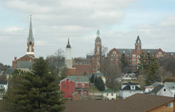 Spires dot Oldenburg’s skyline, a historic village nestled in the hills of southeastern Indiana that was founded by German immigrants in 1837. The onion dome spire, second from left, was recently installed. It was modeled after a similar structure that sat atop Holy Family Parish’s old stone church from 1846 until 1949. (Photo by Sean Gallagher)