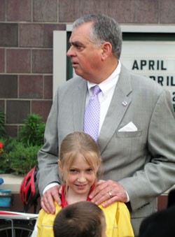 U.S. Transportation Secretary Ray LaHood rests his hands on the shoulders of his granddaughter, Ella Gebke, on April 23, a day that marked the observance of two special events at St. Thomas Aquinas School in Indianapolis—Grandparents’ Day and the celebration of the “Safe Routes to School” program. LaHood is the grandfather of Ella, a second-grade student at St. Thomas, and Henry, a kindergarten student. (Photo by John Shaughnessy)