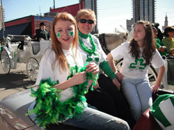 Providence Sister James Michael Kesterson wore a touch of the green and a smile that wouldn’t quit during this year’s St. Patrick’s Day Parade on March 17 in Indianapolis. The principal of St. Jude School in Indianapolis rode in a convertible during the parade. She is flanked by two students, Taylor Mattingly, left, and Nichole Smith. (Submitted photo)