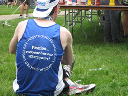 Wearing a team jersey, a member of the Race for Vocations team rests after completing the OneAmerica 500 Festival Mini-Marathon on May 8 in Indianapolis. (Submitted photo by Joe Pedersen)