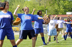 Softball players from Roncalli High School in Indianapolis and John Marshall Community High School in Indianapolis practice together on May 4. The special connection that has developed between the two teams once again shows “the amazing power of God,” according to a Roncalli softball coach. (Photo by Alan Petersime/The Indianapolis Star)