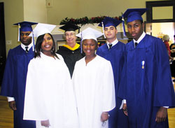 Moments before the first graduation at Providence Cristo Rey High School in Indianapolis on June 9, most of the graduating class posed for a photo with their senior adviser, Providence Sister Maureen Fallon. From left, Quincy Bryant, Janata Williams, Shatera Madding, Simon Arteaga and Jude Okpalannaka pose in their caps and gowns. Missing from the photo is the sixth graduate of the class, Angietoria Lynem. (Photo by John Shaughnessy)