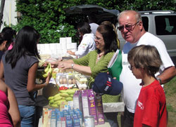 As the founder of a grassroots group that helps the poor, Tim Hahn, second from the right, has learned that his efforts to help others work best when he puts his trust in God. Here, Hahn stands between Amy Moore and 10-year-old Alexander Simons as people in line select the food they want for their families. (Photo by John Shaughnessy)