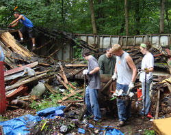 Teenagers and youth ministry leaders from St. Agnes Parish in Nashville and St. Ann, St. Benedict and Sacred Heart of Jesus parishes in Terre Haute provide service to people in need in Brown County as part of the Indiana Nazareth Farm Service Project. The group is shown demolishing a collapsed garage. Organizers are grateful for the energies and dedication of these youths and their adult ministry leaders. (Submitted photo)