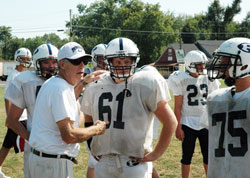 Our Lady of Providence High School football coach Gene Sartini gives instructions to lineman Austin Richards, a junior, during an early season practice. In his 40th season at Providence, Sartini has developed a winning football program that is also strong on faith and family. (Photo by John Shaughnessy)