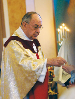 Retired Father Joseph Sheets distributes Communion during a March 19, 2009, Mass at St. Joseph Church in Jennings County. Retired since 2001, Father Sheets has provided sacramental assistance during weekend Masses at many parishes across the archdiocese for nearly a decade. The “Christ Our Hope: Compassion in Community” annual appeal provides support for the archdiocese’s retired priests. (File photo by Mary Ann Wyand)