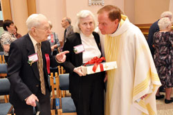 Father George Plaster, the pastor of St. Mark the Evangelist Parish in Indianapolis, congratulates two of his longtime parishioners, Donald and Ruth Allen, on their 70 years of married life following the archdiocesan Golden Wedding Anniversary Mass on Oct. 17 at SS. Peter and Paul Cathedral in Indianapolis. (Photo by Mary Ann Wyand)