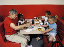 Doris Jackson, an assistant for the preschool operated at Ryves Hall in Terre Haute, helps some of the children at the preschool enjoy a pancake breakfast in June 2004 at the Terre Haute Catholic Charities Food Bank. Catholics in west central Indiana support the programs of Catholic Charities Terre Haute through their contributions to “Christ Our Hope: Compassion in Community.” (File photo by Brandon A. Evans)