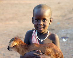 An African boy holding his goat stops to get his picture taken. (Photo by David Siler)