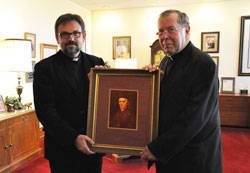 Father Guillaume Bruté, a seminary rector in Beirut, Lebanon, left, and Archbishop Daniel M. Buechlein pose for a photograph on Nov. 8 in the chancery at the Archbishop O’Meara Catholic Center in Indianapolis. They are holding a portrait of the Servant of God Bishop Simon Guillaume Gabriel Bruté de Rémur, Father Bruté’s great-great-great-great uncle. (Photo by Mary Ann Wyand)