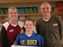 A frightening football injury to Nick Schnell, center, led many people in the Indianapolis Catholic community to pray for him after the Oct. 17 incident. Following his recovery, he posed for a photo with his mother, Angie Schnell, and Kevin Watson, his fifth-grade teacher at St. Roch School in Indianapolis. (Photo by John Shaughnessy)