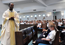 Father Rodolphe Balthazar, the pastor of St. Nicholas Parish in Mole, Haiti, tells Our Lady of the Greenwood students and parishioners about life in the impoverished island nation during his homily on Oct. 22 at Our Lady of the Greenwood Church in Greenwood. He said Haitians walk several miles looking for food and water each day. “When you put your hands together for Haiti, you give hope,” Father Rodolphe said. “You pray for us. You work for us. Thank you for that.”	(Photo by Mary Ann Wyand)