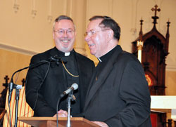 Archbishop Daniel M. Buechlein and Bishop-designate Christopher J. Coyne shake hands during a Jan. 14 press conference at St. John the Evangelist Church in Indianapolis. The archbishop announced that day that Pope Benedict XVI has appointed Bishop-designate Coyne as an auxiliary bishop for the Archdiocese of Indianapolis. (File photo by Mary Ann Wyand)