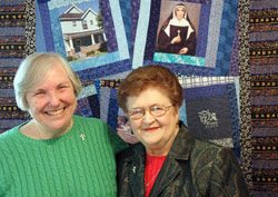 Providence Sisters Barbara McClelland, left, and Rita Ann Wade have been chosen the 2011 Irish Citizens of the Year for their work at Miracle Place, a neighborhood ministry on the near-eastside of Indianapolis. They are shown posing in front of a quilt at Miracle Place. The quilt features a portrait of St. Theodora Guérin, the foundress of their religious order. (Photo by John Shaughnessy)