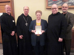 Marilyn Brahm of Ferdinand, Ind., center, was recently recognized by Pope Benedict XVI with the Pro Ecclesia et Pontifice (For the Church and the Pope) award. Pictured with her are, from left, Benedictine Father Adrian Burke, Saint Meinrad’s business manager; Benedictine Archabbot Justin DuVall; Benedictine Father Denis Robinson, the president-rector of Saint Meinrad Seminary and School of Theology, and John Wilson, the general manager of Abbey Press. Brahm worked for 40 years as the executive secretary to four president-rectors at Saint Meinrad, including Archbishop Daniel M. Buechlein. (Photo courtesy of Saint Meinrad Archabbey)