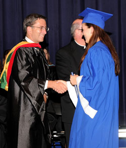 Harry Plummer, executive director of Catholic education and faith formation for the archdiocese, shakes hands with Bishop Chatard High School senior Claire Gorden, a member of Immaculate Heart Parish in Indianapolis, during commencement exercises on May 22 at the school. (Submitted photo)