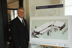 Daniel Elsener, president of Marian University in Indianapolis, stands in front of an architectural rendering of the university’s Center for Health and Healing Arts, which is scheduled to open in 2013. The new building will house the college of osteopathic medicine, and the university’s school of nursing. Marian will be the first Catholic university in the United States to have a college of osteopathic medicine. (Photo by John Shaughnessy)