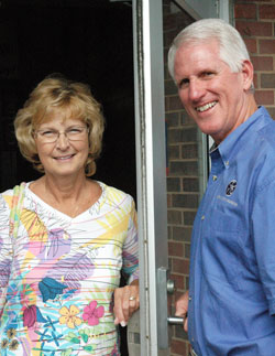 Kathy and Ed Tinder stand by the back door of Roncalli High School in Indianapolis where Ed first showed his romantic interest in Kathy 38 years ago when they both taught at the school. In their 37 years of marriage, the Tinders have dedicated their lives to young people through Ed’s leadership of the Catholic Youth Organization and Kathy’s career as a teacher. (Photo by John Shaughnessy)