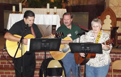 Father Juan Valdes, left, parish administrator of St. Mary Parish in Lanesville, who also ministers to the Hispanic community in the New Albany Deanery, Al Klein and Leslie Lynch sing bilingual songs during a Hispanic music event at St. Mary Church in Lanesville on May 15. (Submitted photo)