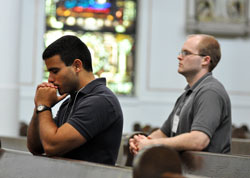 Seminarians Matthew Tucci, left, and David Marcotte kneel in prayer during an Aug. 17 Mass at St. Mary Church in Richmond. Archdiocesan seminarians went on pilgrimage to the three parishes that make up the Richmond Catholic Community that day. Tucci is a member of Holy Family Parish in New Albany, and Marcotte is a member of St. Michael Parish in Greenfield. Both men are in formation at Saint Meinrad Seminary and School of Theology in St. Meinrad. (Photo by Sean Gallagher)