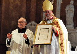 Msgr. Joseph Riedman acknowledges the applause of well-wishers during an Aug. 14 Evening Prayer Liturgy during which he and four other archdiocesan priests were honored as new monsignors. Bishop Christopher J. Coyne presented the new monsignors with certificates from Pope Benedict XVI that certify his bestowing on them their ecclesiastical honor. (Photo by Sean Gallagher)