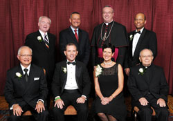 An archdiocesan celebration of Catholic education on Oct. 26 honored six individuals whose Catholic values mark their lives. Standing, from left, are honoree Glenn Tebbe, keynote speaker and Indiana superintendent of public instruction Tony Bennett, Bishop Christopher J. Coyne and honoree Dr. Louis Wright. Sitting, from left, are honorees Eduardo Parada, Robert Steiner, Ann Steiner and Msgr. Joseph Riedman. (Photo by Rob Banayote)