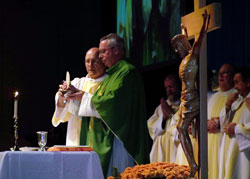 Bishop Christopher J. Coyne, apostolic administrator, center, and Deacon Lawrence French, left, elevate the Eucharist at the conclusion of the eucharistic prayer during a Mass celebrated on Oct. 29 at the Indiana Convention Center in Indianapolis. The Mass was part of the Indiana Catholic Men’s Conference that drew more than 800 men and young men from across the state. (Photo by Bryce Bennett)