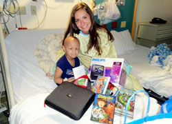 At 18, Liz Niemiec has used her Catholic faith to start the Little Wish Foundation, an organization that makes small wishes possible for children stricken with cancer. Here, she poses at Riley Hospital for Children in Indianapolis with 3-year-old Riley, a Richmond child who wanted a portable DVD player and movies. (Submitted photo)