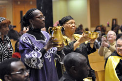 Holy Angels parishioner Marsha Carter of Indianapolis, left, and St. Rita parishioner Mary Guynn of Indianapolis present the offertory gifts during the African Catholic Mass on Dec. 4 at St. Rita Church in Indianapolis. (Photo by Mary Ann Garber)