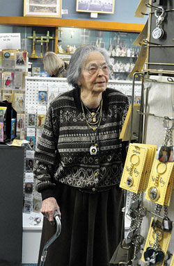 Anne Krieg looks at merchandise at Krieg Bros. Religious Supply House on Dec. 3, the last day of operation of the nearly 120-year-old business in downtown Indianapolis. A member of Immaculate Heart of Mary Parish in Indianapolis, Krieg, 91, managed the store for three decades until it closed. (Photo by Sean Gallagher)