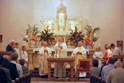 Bishop Christopher J. Coyne, center, apostolic administrator, prays the eucharistic prayer during a Nov. 6 Mass at St. John the Baptist Church in Starlight that celebrated the New Albany Deanery faith community’s 150th anniversary. Concelebrating the Mass were, from left, Father Harold Ripperger, a former administrator of the parish, and Father Wilfred “Sonny” Day, current pastor. (Submitted photo)