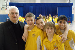 During his 10 years as the superintendent of Catholic schools in the archdiocese, Ron Costello has stressed a combination of academic excellence and values-based education. Here, Costello, who will retire on Dec. 31, poses for a photo with four students at Holy Name of Jesus School in Beech Grove. They include Dolan Monroe, left, Brad Meade, Zach Taylor and Gabriel Lopez. The photo was taken at the school after a Dec. 7 ceremony honoring Benedictine Sister Mary Nicolette Etienne, a religion teacher. (Photo by John Shaughnessy)