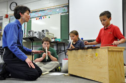 Benedictine Sister Marie Racine, the music teacher and choir director at St. Malachy School in Brownsburg, works with fourth-graders, from left, Joey Wynne, Sydney Arnes and Ben Zimmerman as they play recorders and a xylophone. Sister Marie is a member of the Sisters of St. Benedict of Our Lady of Grace Monastery in Beech Grove. (Photo by Mary Ann Garber)